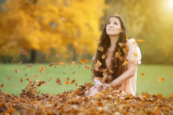 Hermosa mujer entre hojas de otoño — Foto de Stock