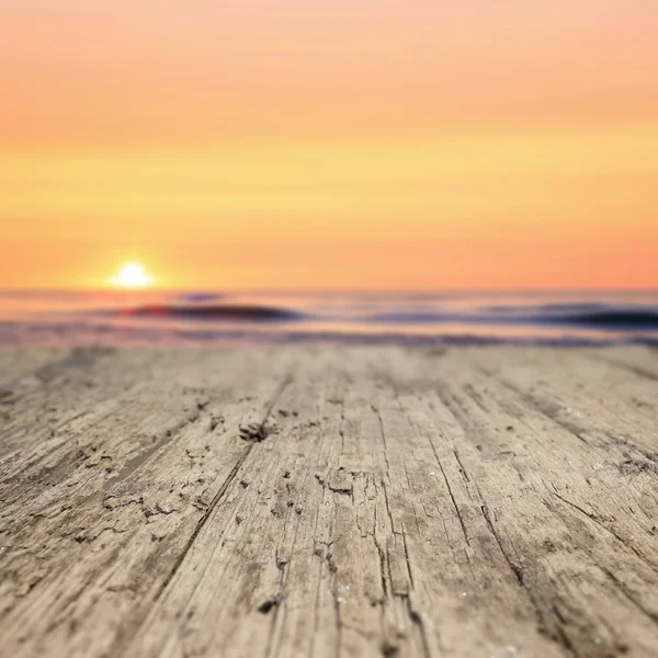 Houten planken op het strand bij zonsondergang — Stockfoto