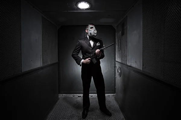 Мужчина с винтовкой и противогазом в старом лифте — стоковое фото