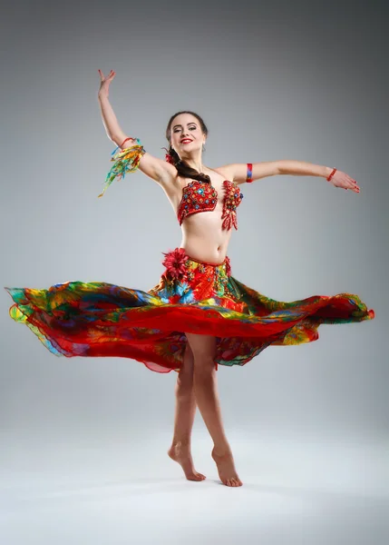 Beautiful young woman in a dress dancing in the studio — Stock Photo, Image