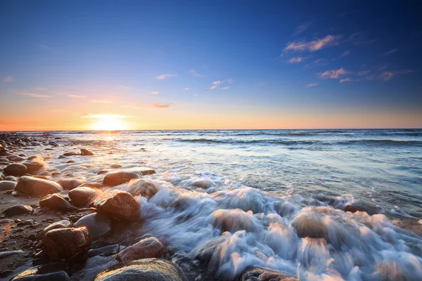 Pôr do sol sobre o mar Báltico. A praia de seixos em Rozewie — Fotografia de Stock