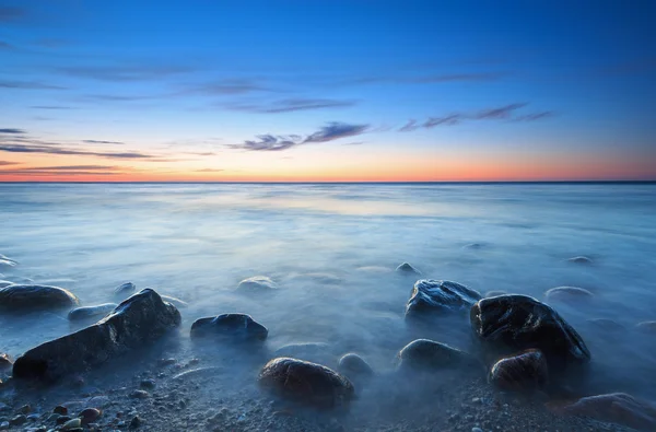 Puesta de sol sobre el mar Báltico. La playa de guijarros en Rozewie — Foto de Stock