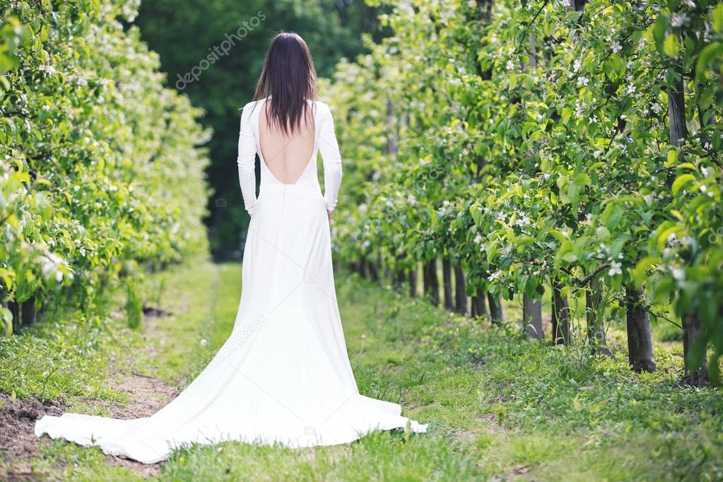 Woman in a white dress in the orchard