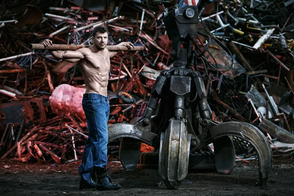 Muscular man working on junkyard — Stock Photo, Image