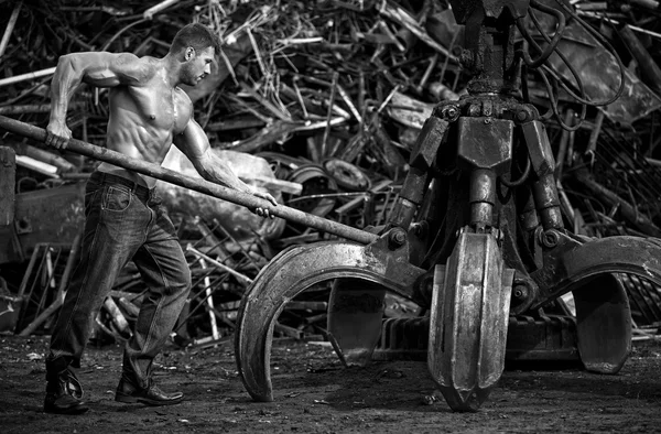Hombre musculoso trabajando en el depósito de chatarra — Foto de Stock
