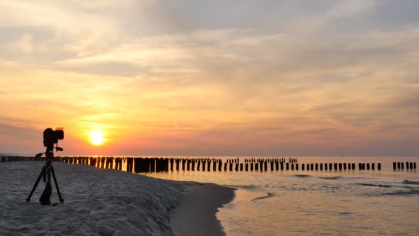 Câmera fotográfica na praia ao pôr do sol no Mar Báltico — Vídeo de Stock