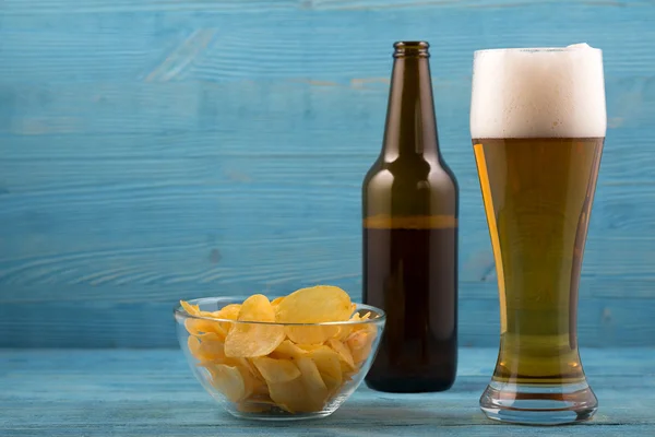 Beer and chips on a blue background — Stock Photo, Image