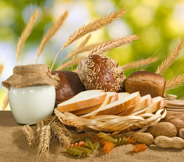 Pan, nueces, trigo y lácteos sobre fondo de agua —  Fotos de Stock