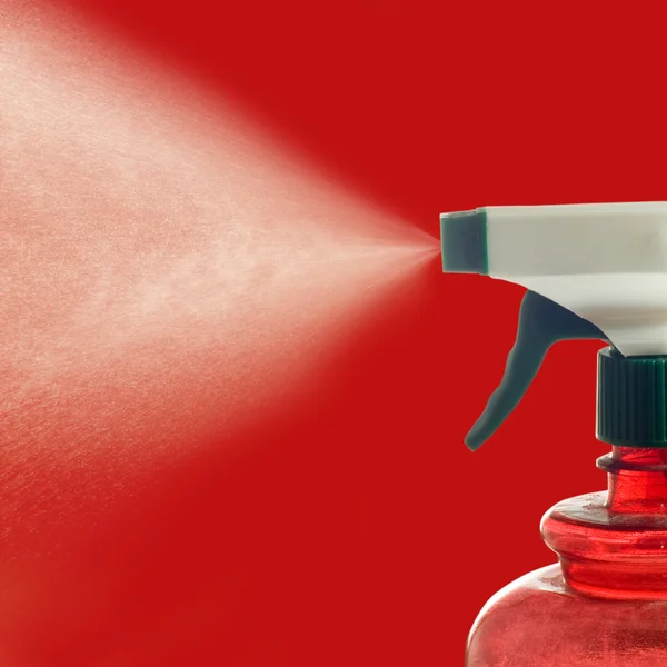 Image of water sprayed from a spray on a red background close-up — Stock Photo, Image