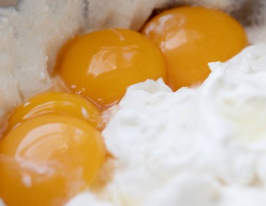 Krema yapmak için karıştırmadan önce beyaz protein kütlesinin arka planında tavuk yumurtası sarısı var.