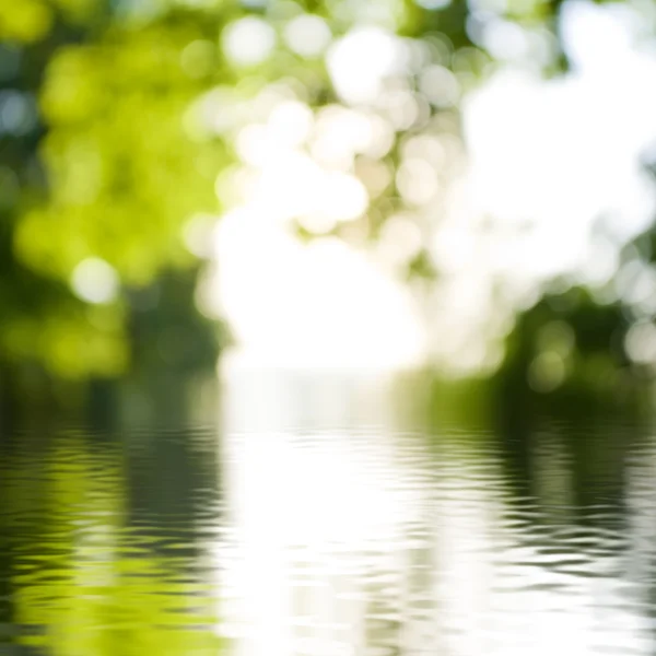Yeşil arka plan bulanık su yüzeyine — Stok fotoğraf