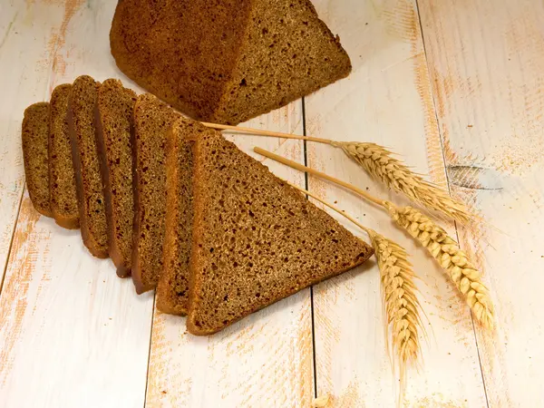 Brood en tarwe op tafel — Stockfoto