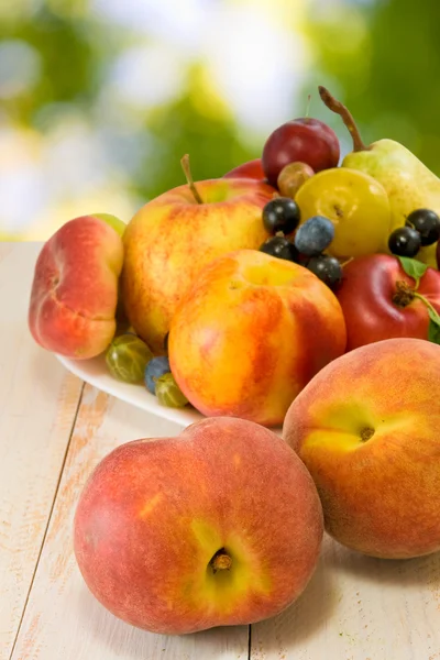 Image of different fruits on a plate on a blurred background — Stock Photo, Image