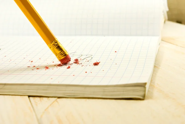 Pencil with eraser on exercise book background — Stock Photo, Image