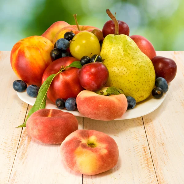 Different fruits on green background — Stock Photo, Image