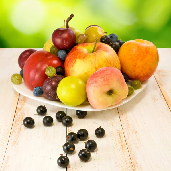 Image of various fruits on a table on green background — Stock Photo, Image