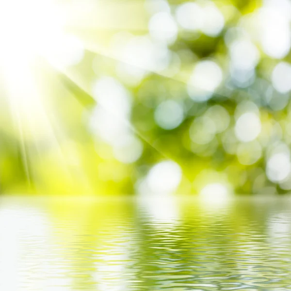 Yeşil arka plan bulanık üzerinde su — Stok fotoğraf