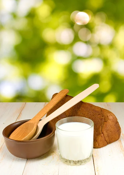 Brot und ein Glas Milch auf grünem Hintergrund — Stockfoto