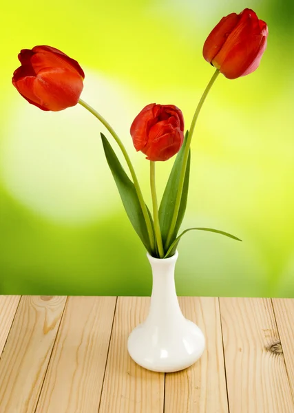 Trois fleurs tulipes dans un vase sur un fond vert gros plan — Photo