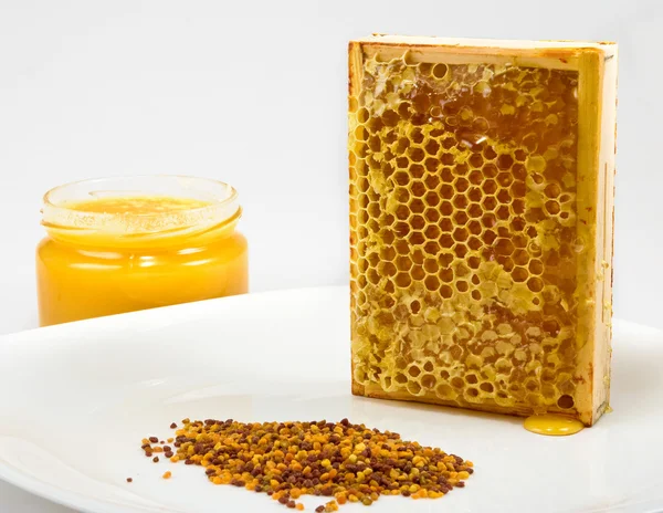 Honung, honeycomb och pollen på en tallrik — Stockfoto