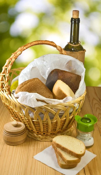 Basket with bread and a bottle of wine — Stock Photo, Image