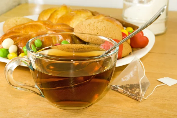 Tasse de thé, gâteaux et petits pains sur la table — Photo