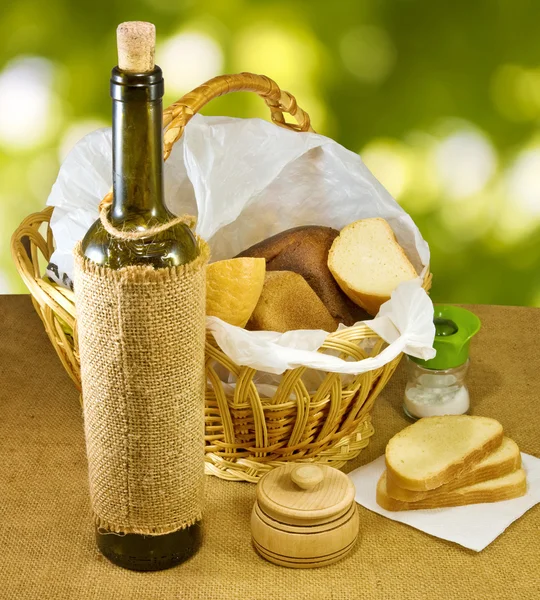 Image of a basket with bread and a bottle of wine — Stock Photo, Image