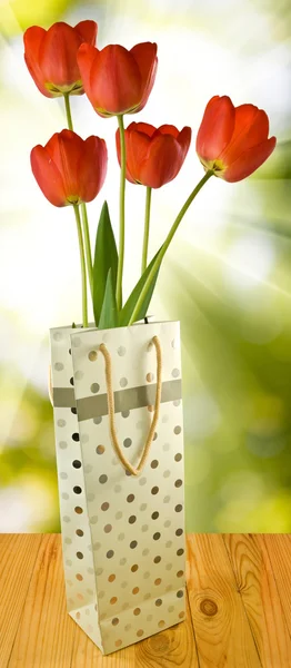 Květiny v dárkové balení na zeleném pozadí — Stock fotografie
