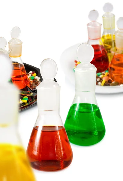 Flasks with colored liquid and pills — Stock Photo, Image