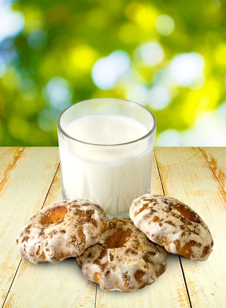 Melk en koekjes op groene achtergrond close-up — Stockfoto