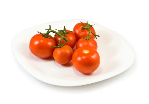 Tomates en un plato sobre un fondo blanco —  Fotos de Stock