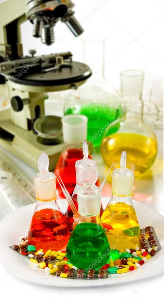 image of Chemical flasks, microscope and pills closeup