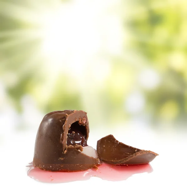 Изображение вкусного шоколада с вишней на зеленом фоне — стоковое фото