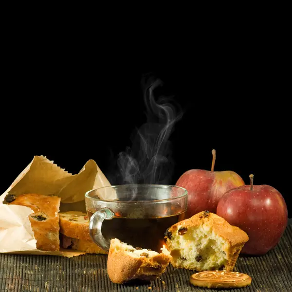 Imagen de taza de té, galletas y manzanas sobre un fondo negro —  Fotos de Stock