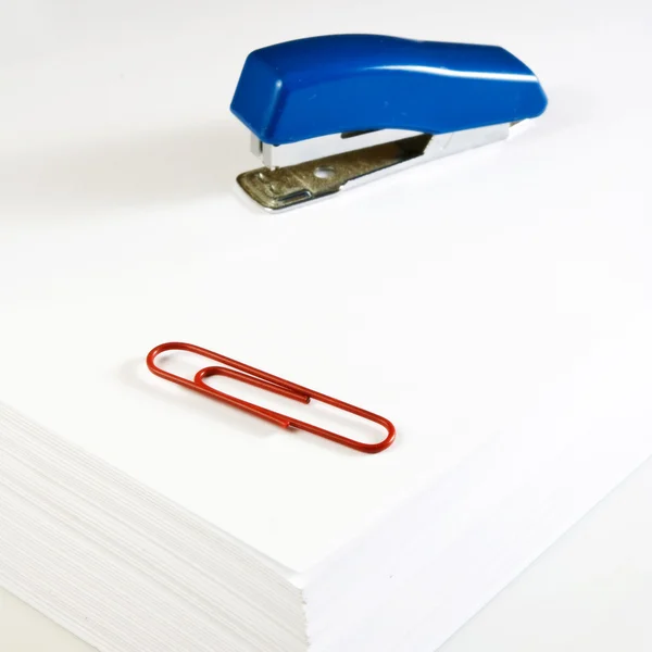 Pilhas de papel, grampeador e clipes close-up — Fotografia de Stock
