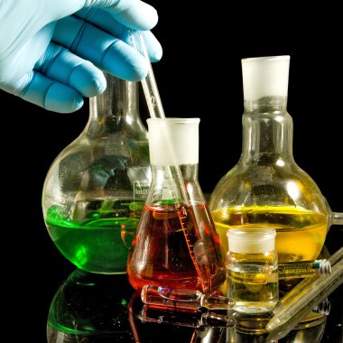  bir elinde bir siyah arka plan portre üzerinde bir eldiven ve laboratuvar cam ürünleri