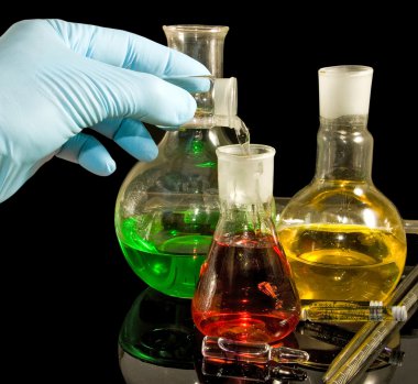  bir elinde bir siyah arka plan portre üzerinde bir eldiven ve laboratuvar cam ürünleri