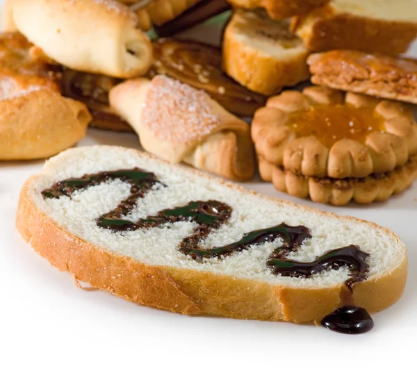 Image tranche de pain blanc arrosée de chocolat liquide et biscuits — Photo