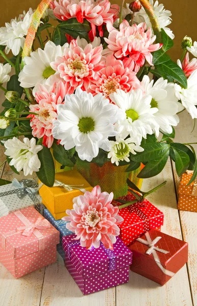 Obrazy květiny a dárkové krabičky na dřevěný stůl — Stock fotografie