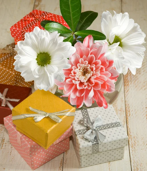 Bilder von Blumen und Geschenkschachteln auf einem Holztisch in Großaufnahme — Stockfoto