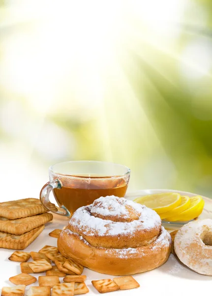 Image de tasse de thé et différents biscuits contre le soleil — Photo