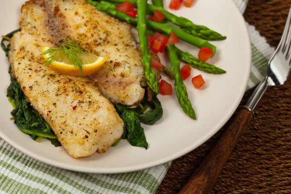 Tilapia met gebakken spinazie — Stockfoto