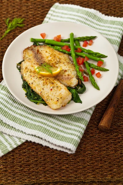 Tilapia med sauterad spenat — Stockfoto