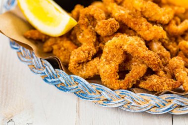 Çıtır Patlamış Midye Şeritli Atıştırmalık. Bol yağda kızartılmış midye parmaklar ve tahtanın üzerinde Tatar soslu kızarmış patates. Seçici odak.