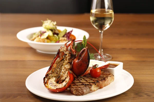 Izgara karides ve biftek mükemmel beyaz bir plaka üzerinde ızgara