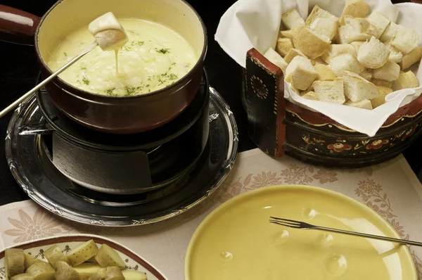 cheese fondue - a piece of bread croutons in a liquid cheese