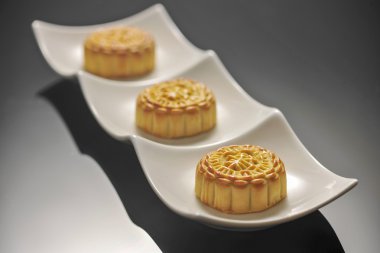 Beyaz bir plaka üzerinde üç geleneksel mooncakes