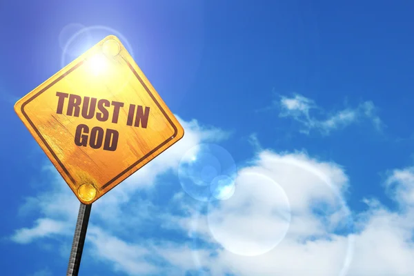 Yellow road sign with a blue sky and white clouds: trust in god — Stock Photo, Image