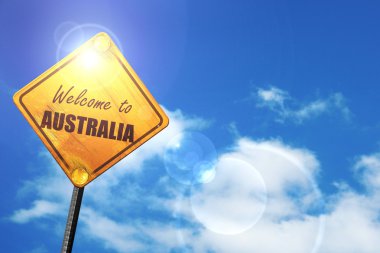 Yellow road sign with a blue sky and white clouds: Welcome to au