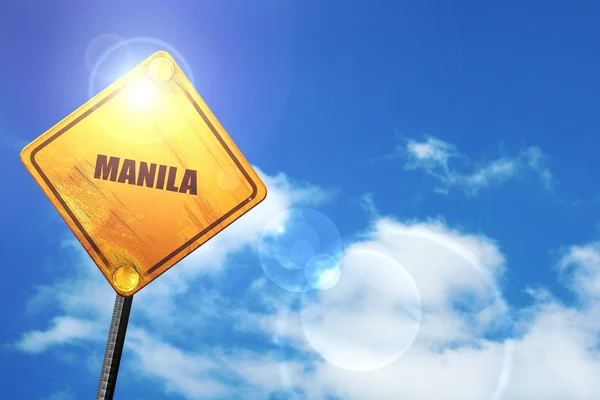 Yellow road sign with a blue sky and white clouds: manila — Stock Fotó
